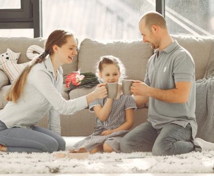 A joyful family enjoying quality time and coffee in a bright living room, symbolizing love and togetherness.
